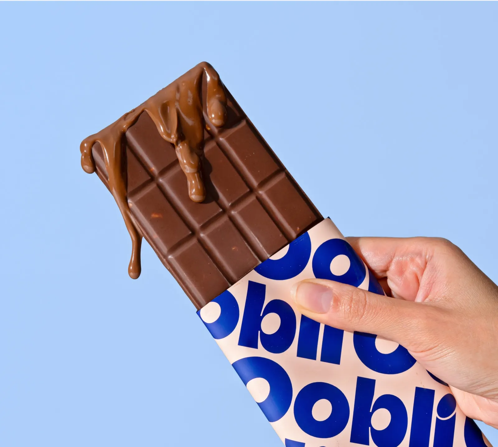Oobli milk chocolate bar with caramel on a pale blue background